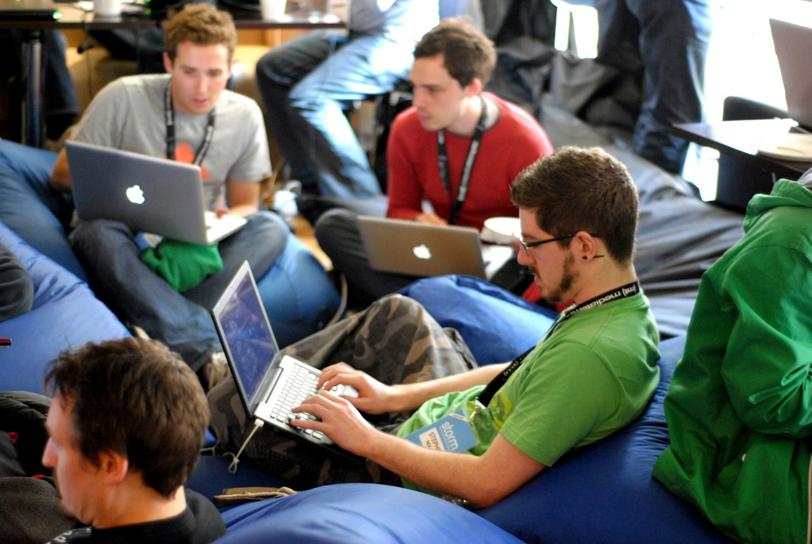 man sitting on blue bean bag usinglaptop